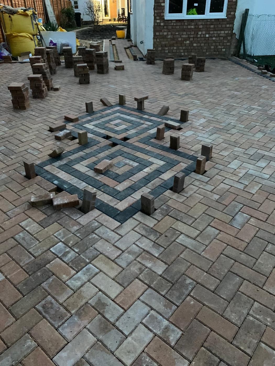 Herringbone block paved driveway with a charcoal diamond centre feature part laid