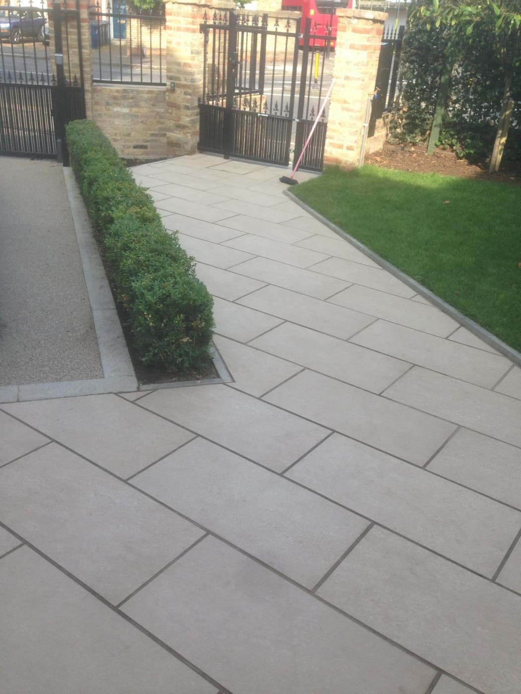 Porcelain plank paving laid to a front path beside a resin driveway with clipped box hedge