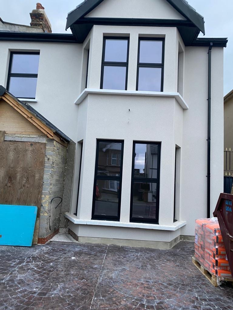 Newly rendered elevation in cream with black bay windows