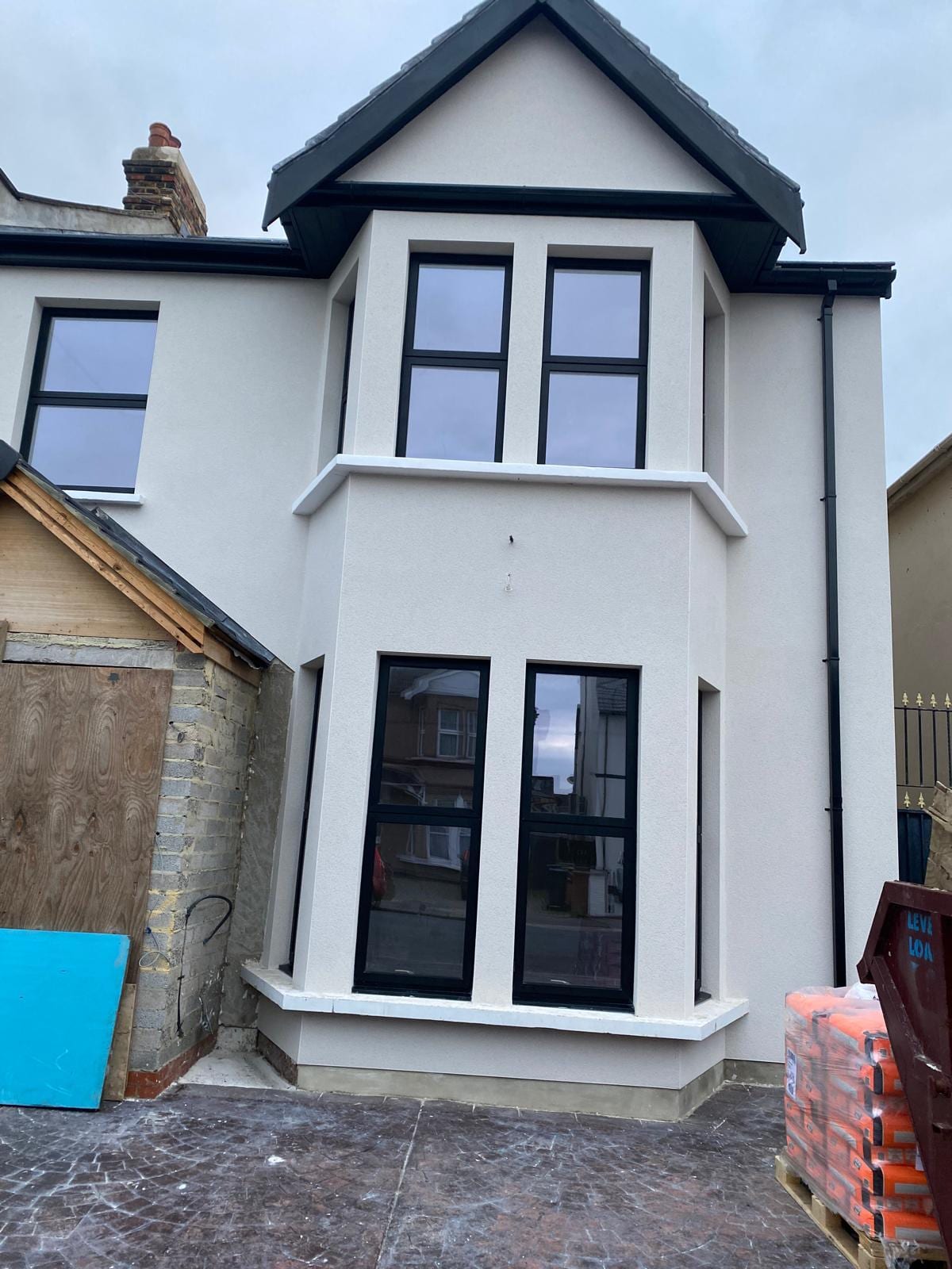 Smooth cream render on a bay elevation with black windows