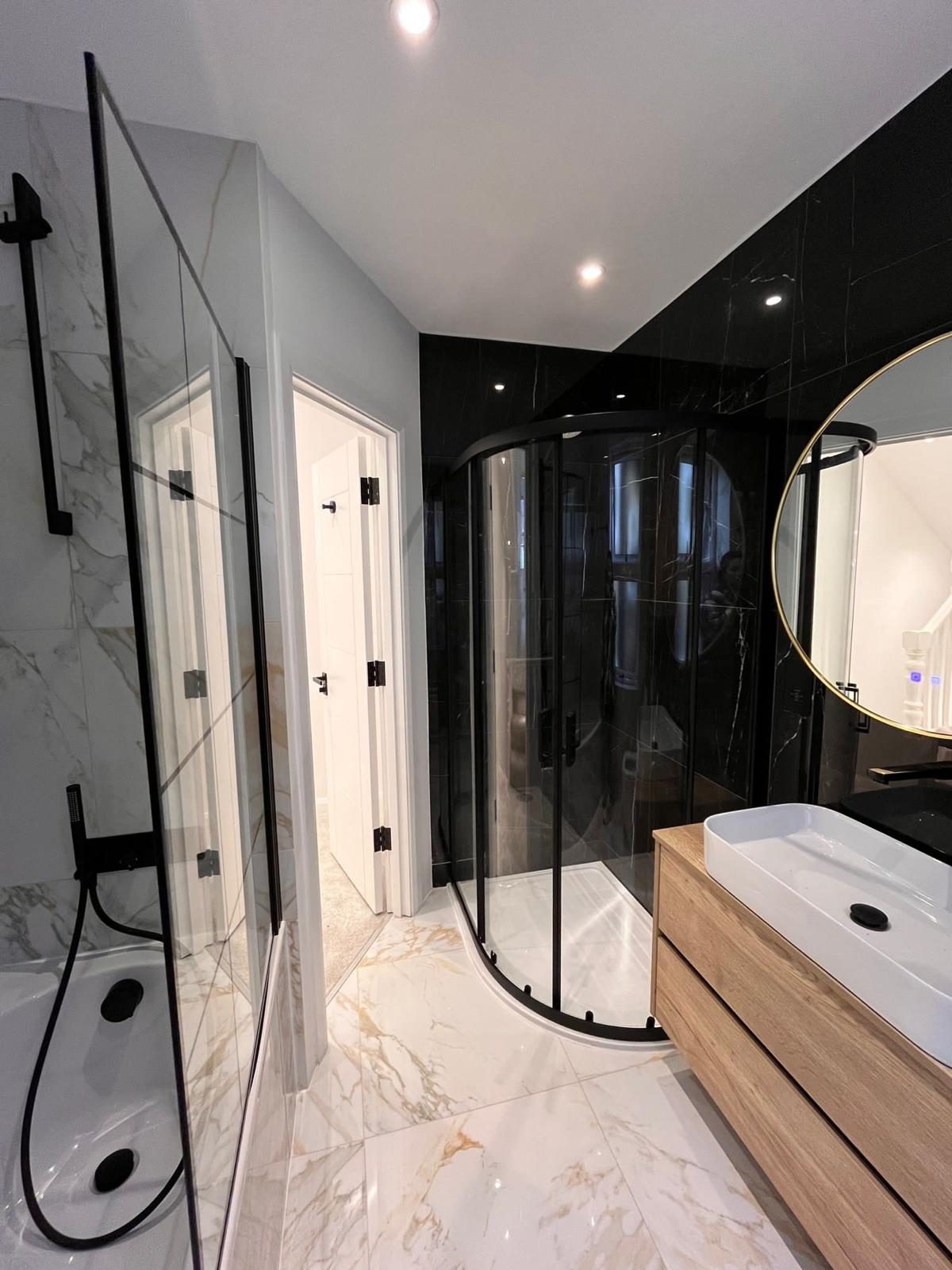Marble bathroom with walk-in shower and gold mirror